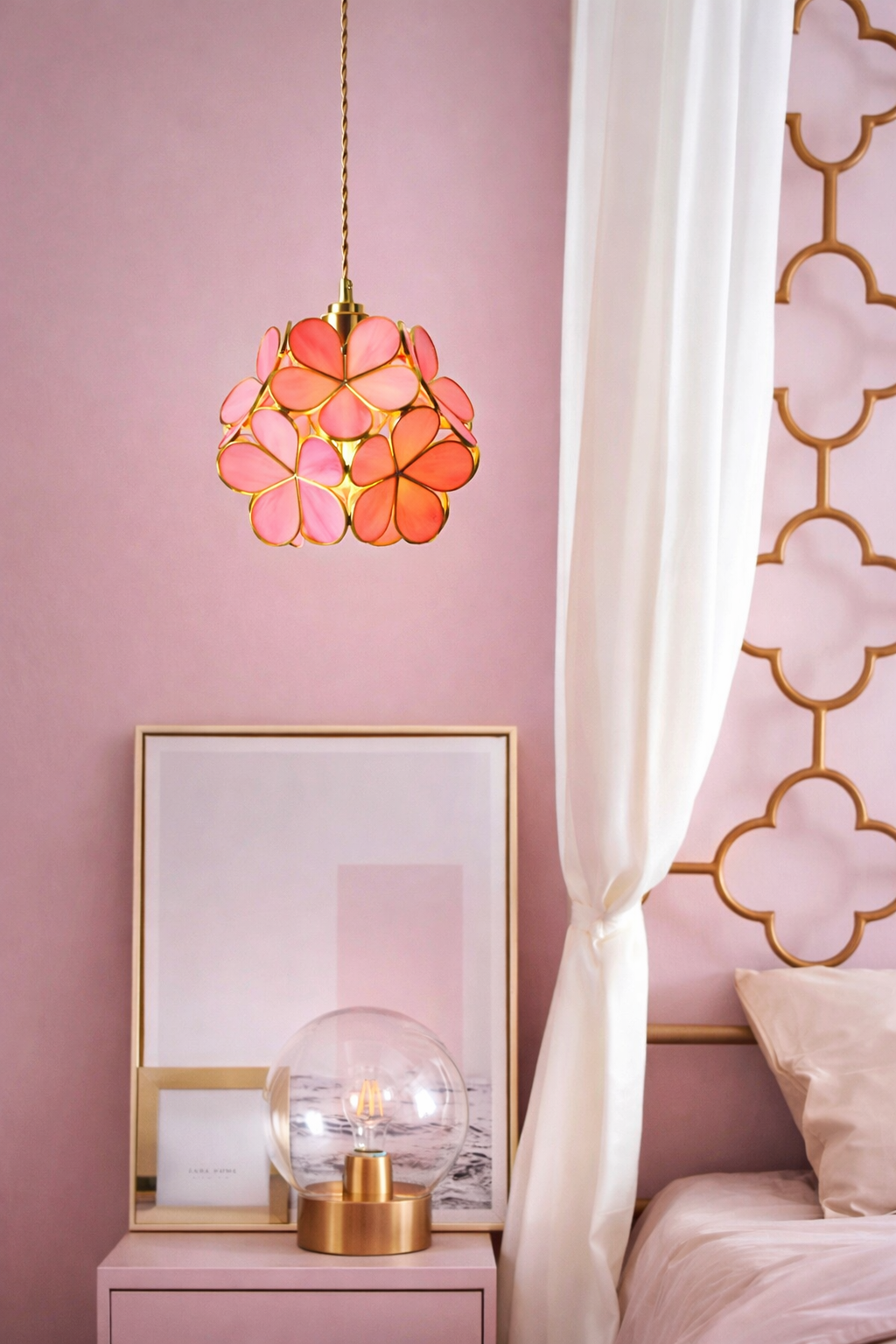 Handmade pink glass floral pendant light, adding a soft, luxury accent to a bedroom.