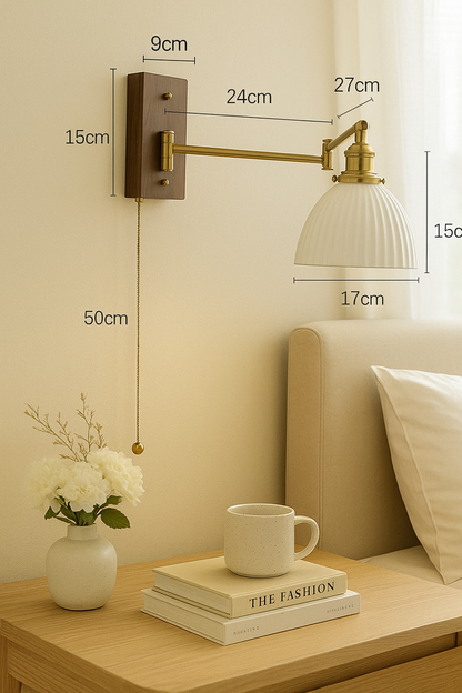 Artisanal ceramic wall light with natural shape shade, brass arm, and wood mount installed at bedside