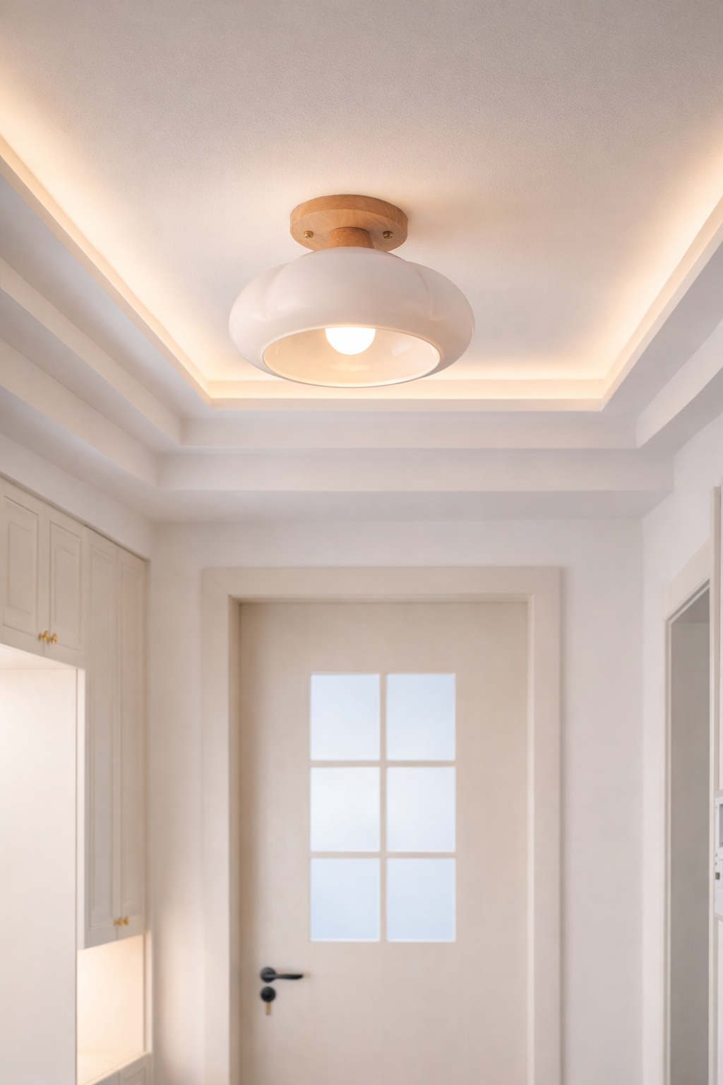 Modern organic-shaped white ceiling light illuminating a minimalist entryway foyer.
